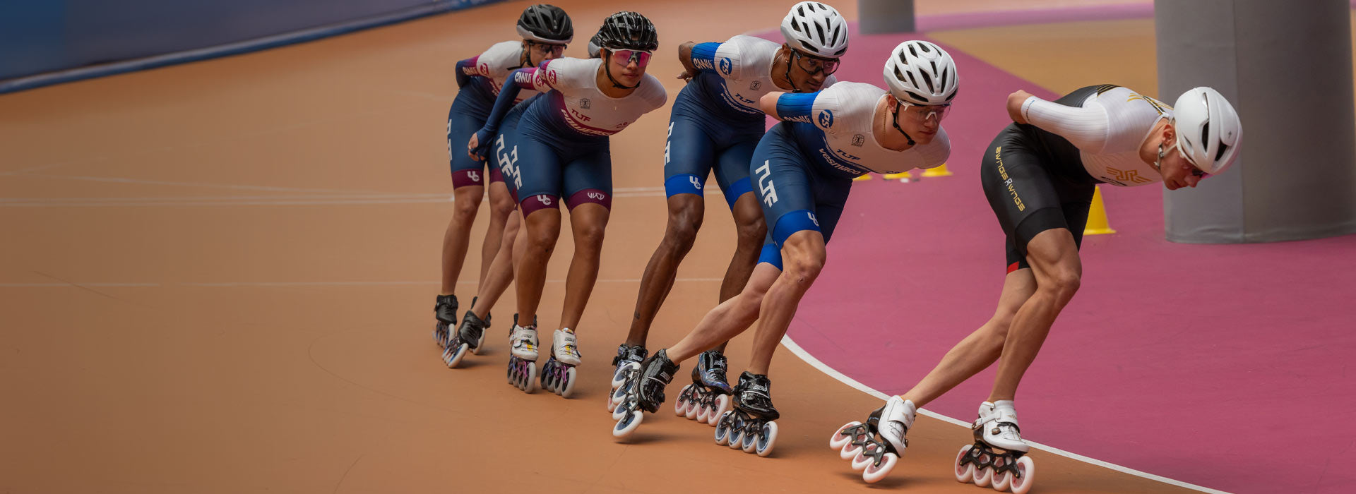 An inline speed skater wearing a tight blue outfit skating toward the camera 