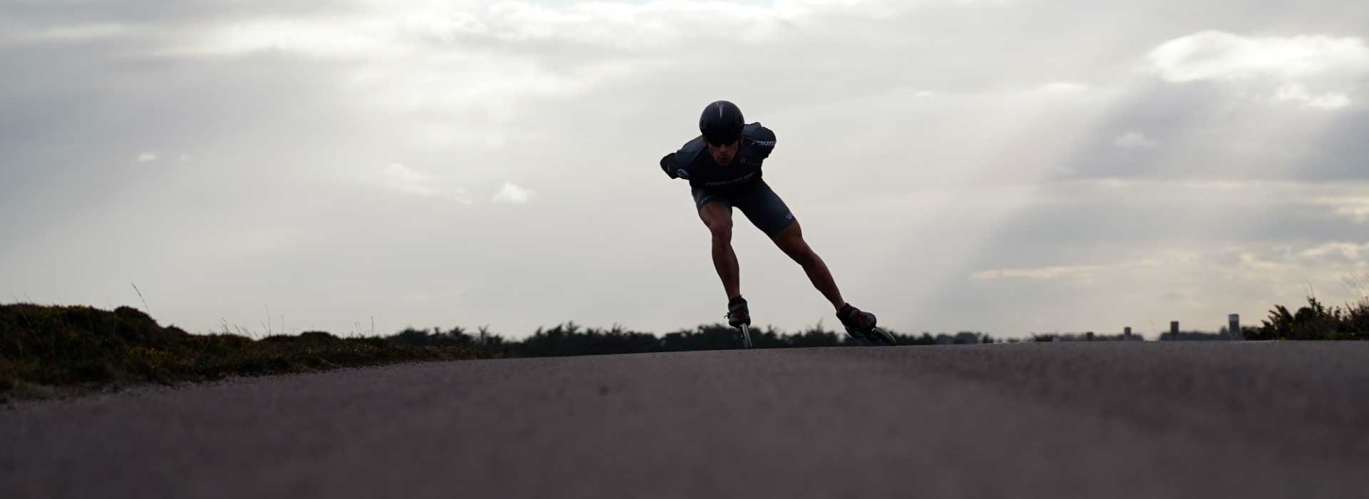 An inline marathon skater mid-stride skating toward the camera in Powerslide inline race skates